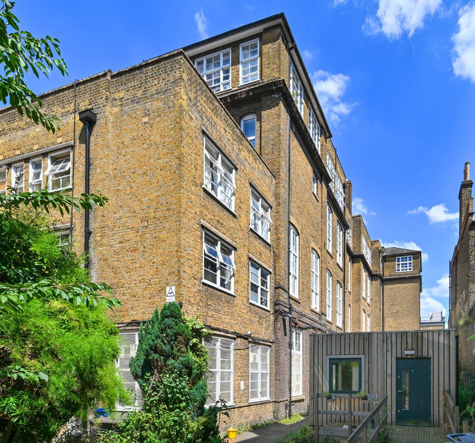 The brick facade of the Victorian school with its tall windows